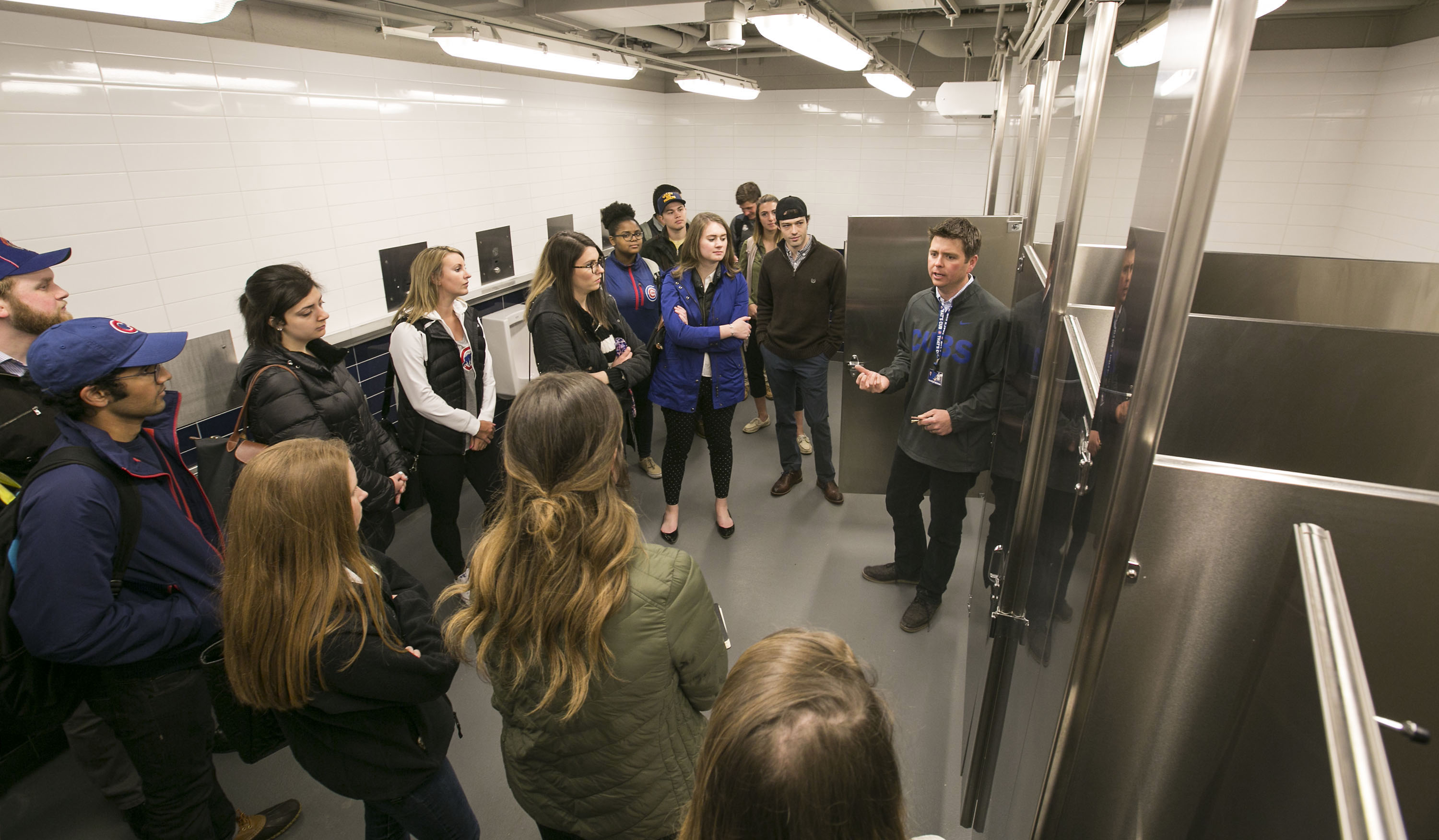 Patrick Meenan, right, senior director, facilities and procurement for the Chicago Cubs, leads a group of DePaul University students from Don Ingle's public relations and advertising class through a water sustainable bathroom at Chicago's Wrigley Field on May 10. (DePaul University/Jamie Moncrief)