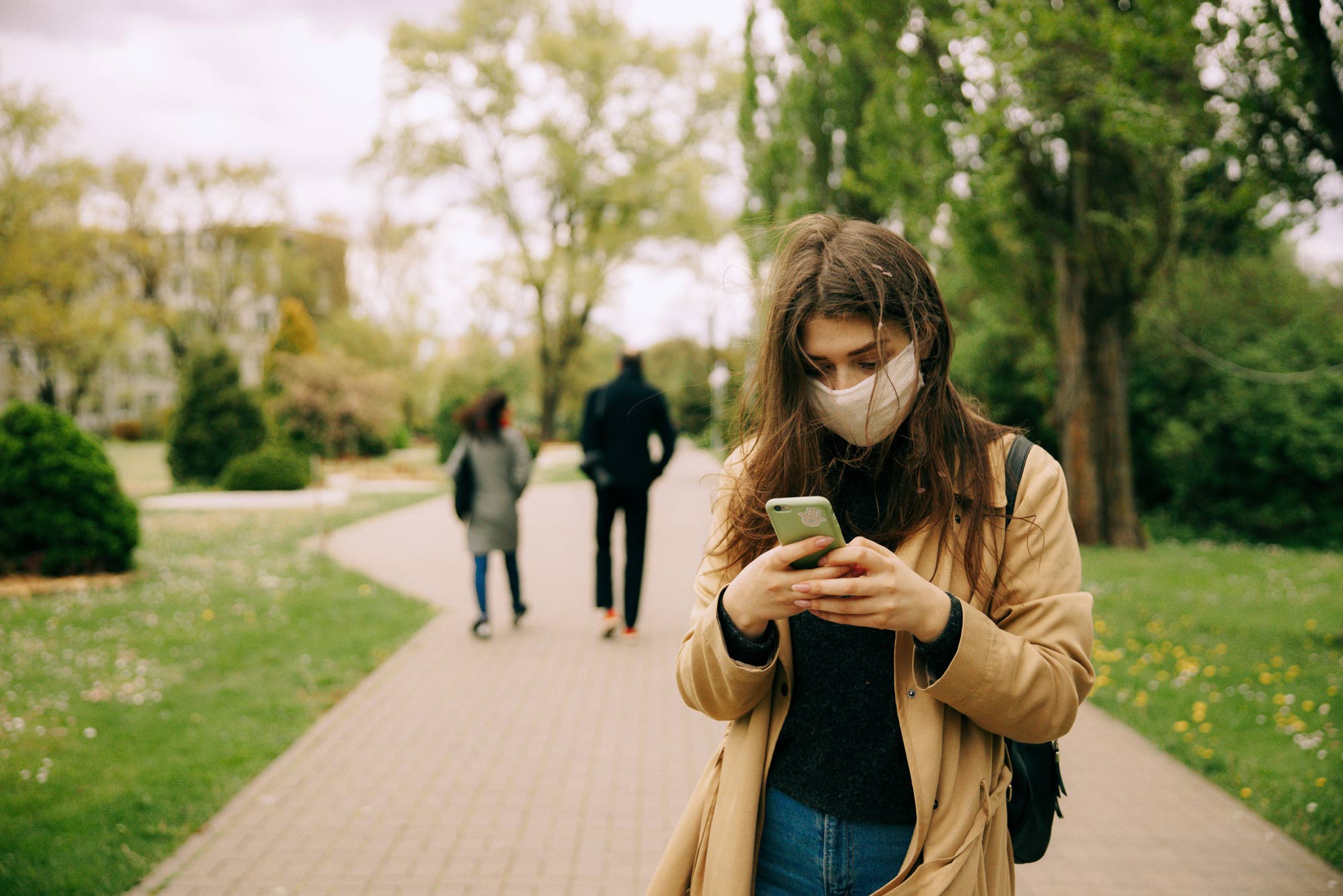 Woman wearing a mask holding phone